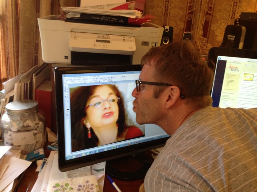 Schuyler Hoffman throwing a kiss to a photo of Adrian Leeds on the computer monitor